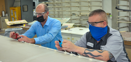 Bongiovi rep Rob Hamelink and Duncan Aviation avionics modifications specialist Ritchie Peterson work on installing transducers for the Bongiovi Aviation audio system