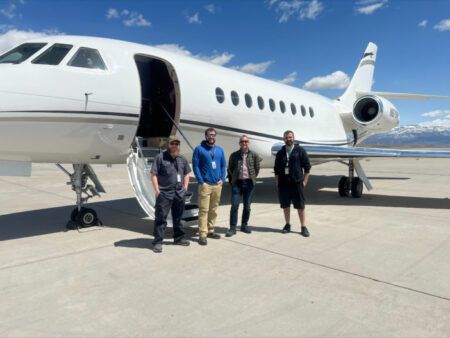 The Falcon STC install team of four, standing in front of an aircraft on the tarmac