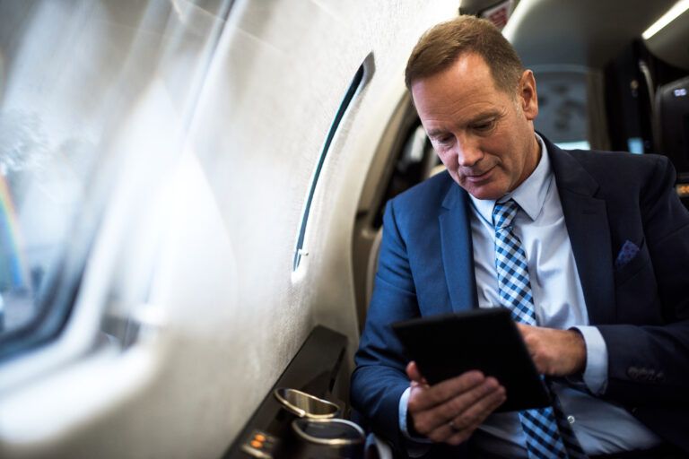 A passenger using a tablet in a business jet