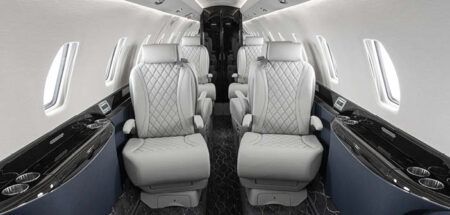 The interior of the Citation 750 overhauled by Duncan Aviation – featuring grey seats with quilted double-stitched diamond pattern inserts; navy lower sidewalls; black composite ebony veneer; satin chrome plating; and a dark carpet with light accents