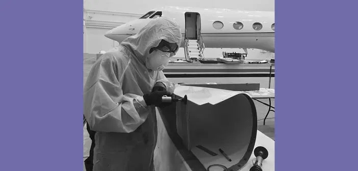 Technician working on a component with aircraft in background