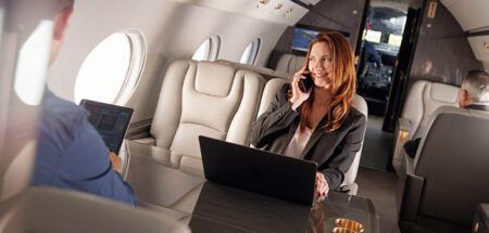 Passengers using phones and tablets on business jet