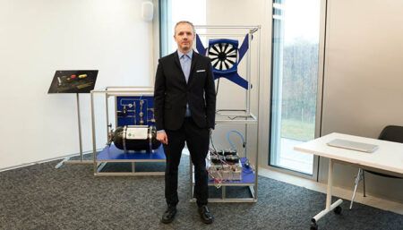 Alexey Popov standing in front of the hydrogen-electric propulsion system