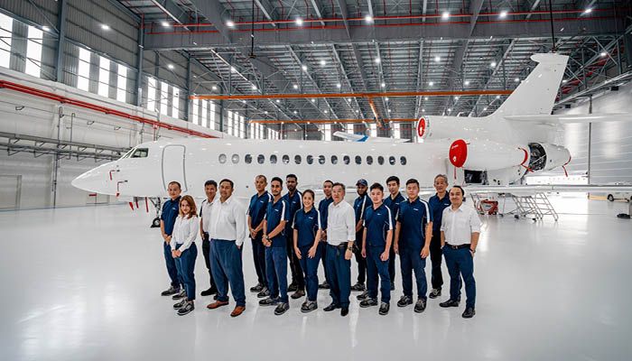 Group photo in front of Falcon 8X in hangar