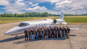 Team photo in front of aircraft