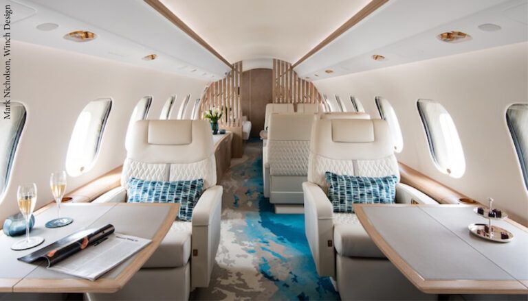 VIP aircraft interior with light-coloured seats and blue and cream carpet