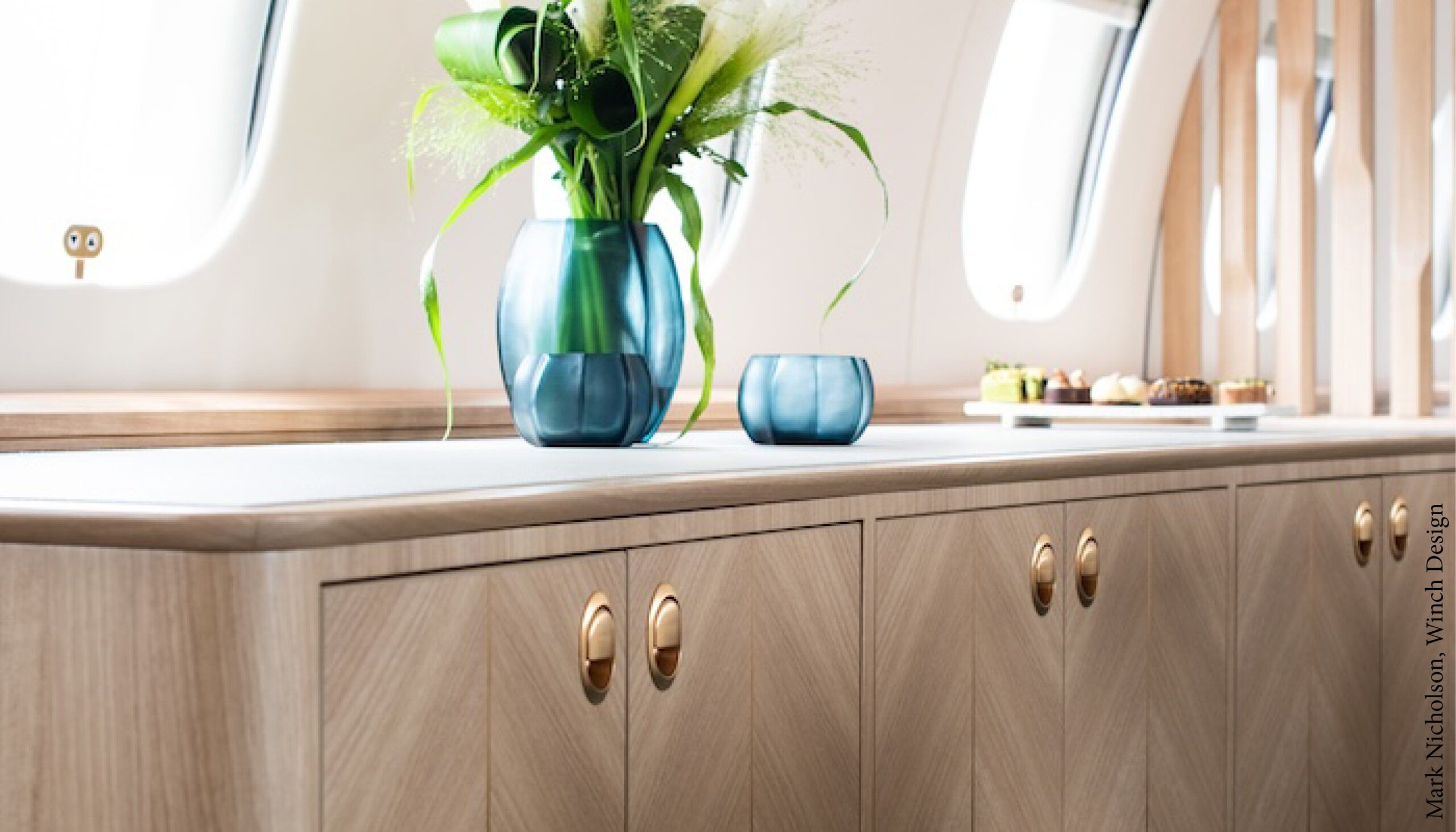 aircraft cabinets against sidewall with blue vase on top