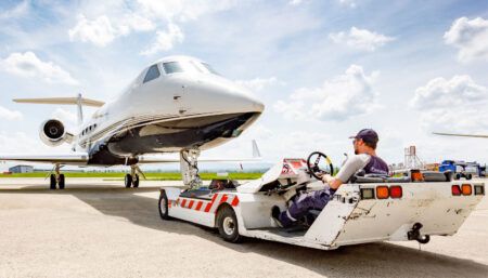 business jet being towed at airport