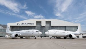 two aircraft in front of a hangar