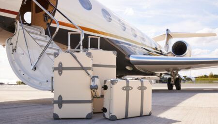 luggage on ground outside a private jet