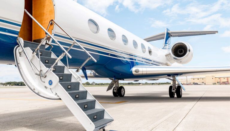 business jet at airport with stairs leading up to open door