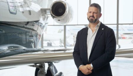 Tarek Muhiddin standing in hangar with aircraft in background