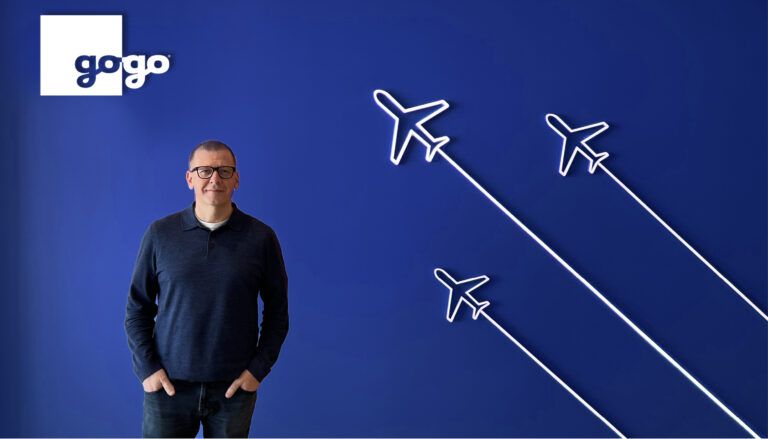 Chris Moore in front of blue backdrop with Gogo brand logo and aircraft outlines