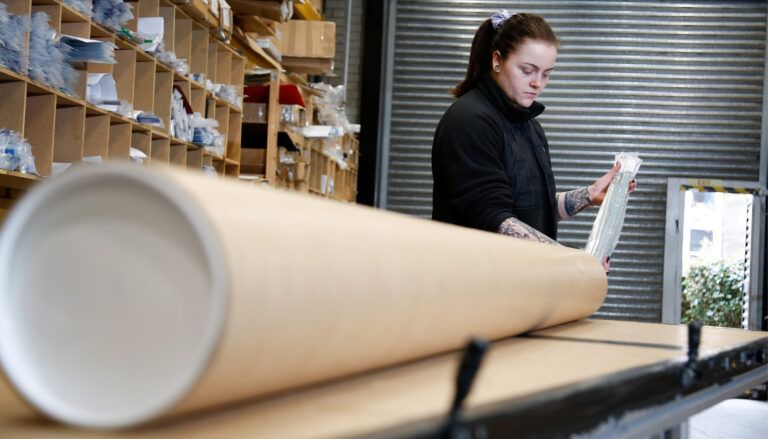 worker putting floor-path marking product into tube packaging