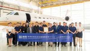 group photo in front of aircraft with ribbon in front