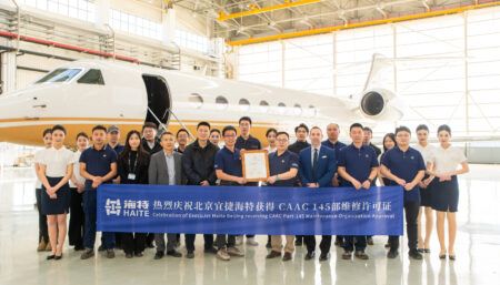 group photo in front of aircraft with ribbon in front