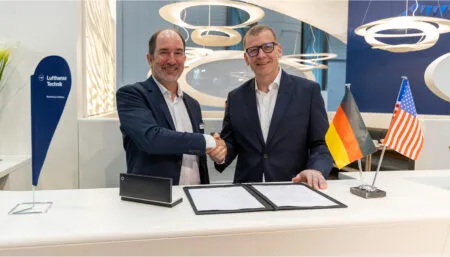 Andrew Muirhead and Chris Moore shake hands upon signing the agreement