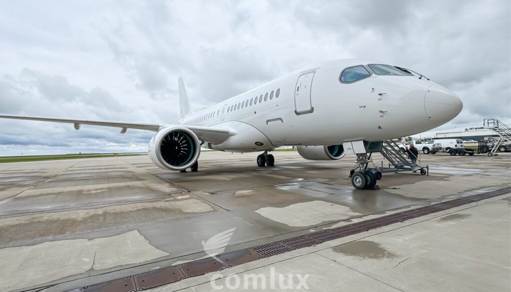 White aircraft on tarmac with landing gear extended