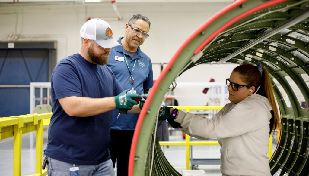 three people with aircraft fuselage section