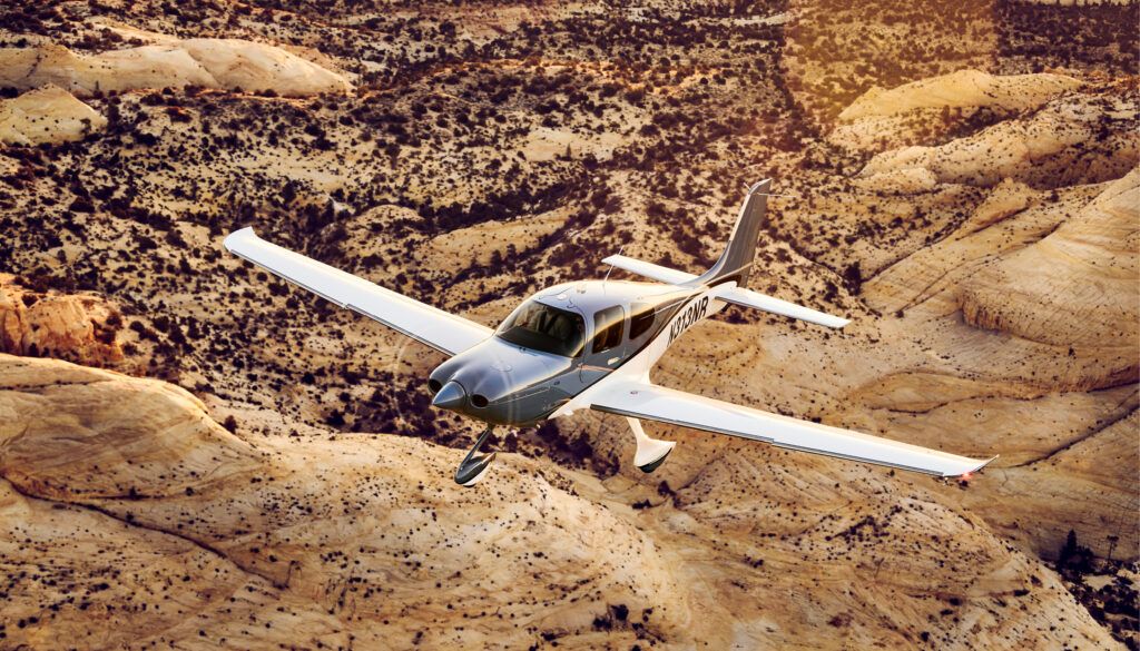 single-engine piston aircraft flying over arid landscape