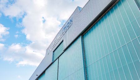 aircraft hangar exterior - large green building with Jet Aviation logo at the top