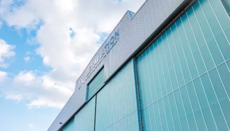 aircraft hangar exterior - large green building with Jet Aviation logo at the top
