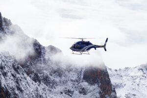 Helicopter flying over snowy mountains