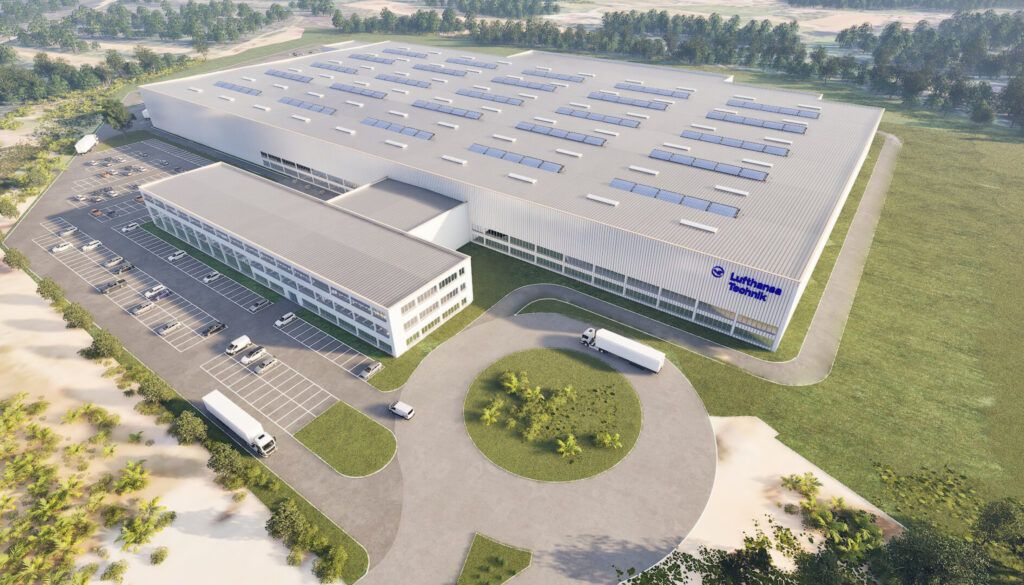 Aerial view of modern facility with solar panels and parking area