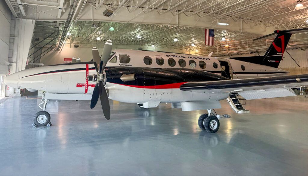 White King Air turboprop aircraft with "Special Missions" text in hangar facility