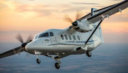 White twin-engine Cessna SkyCourier aircraft flying against sunset sky