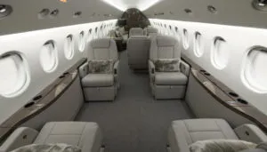 Luxurious private jet interior with beige leather seats and wood accents