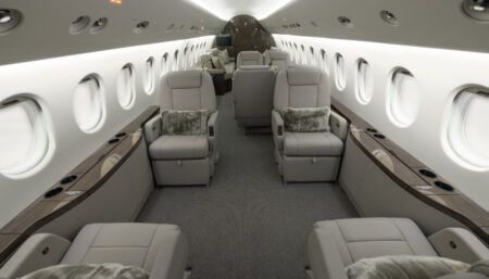 Luxurious private jet interior with beige leather seats and wood accents