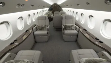 Luxurious private jet interior with beige leather seats and wood accents