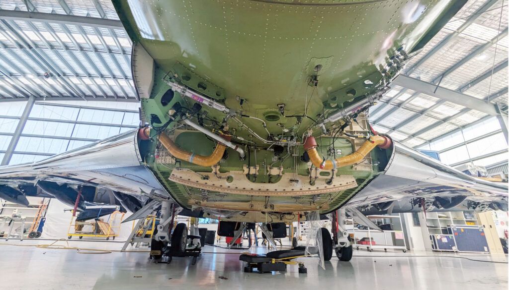 Underside view of aircraft during maintenance work