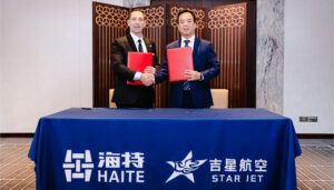 Two businessmen in suits shaking hands while holding red folders at signing ceremony