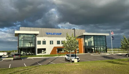 Contemporary aircraft facility building with glass windows and modern architectural design, with Pilatus logo