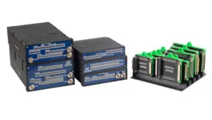 Test equipment modules with blue faceplates and connector ports, alongside green circuit board modules in a rack system