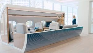 Modern aircraft cabin interior mock-up with luxury seating and two women examining design
