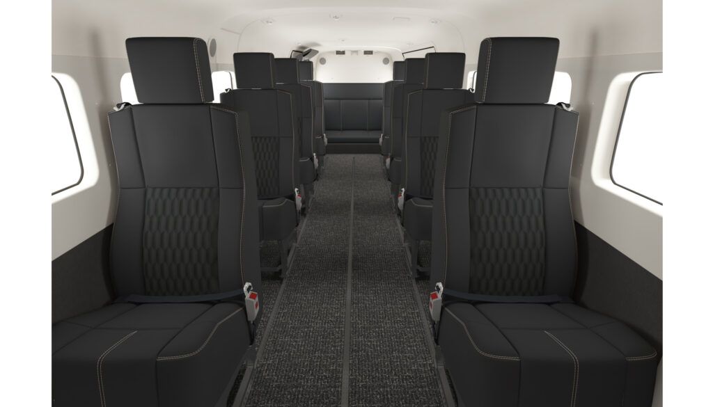 Aircraft cabin featuring black leather seats with quilted pattern inserts, in forward-facing rows with centre aisle