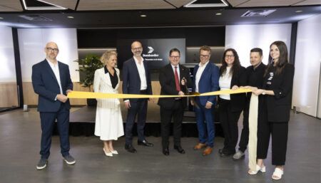 Group of executives cutting yellow ribbon at opening ceremony