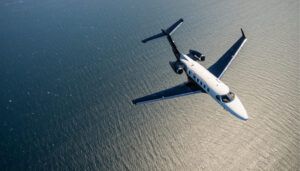 Business jet flying over water