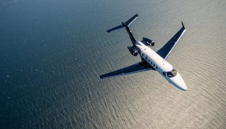 Business jet flying over water