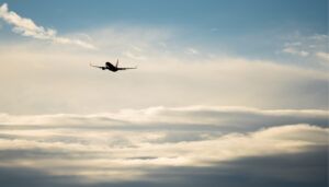 Stock image – aircraft in flight above clouds in blue sky
