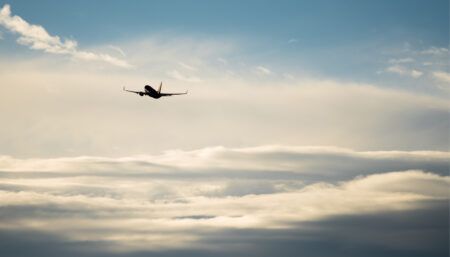 Stock image – aircraft in flight above clouds in blue sky