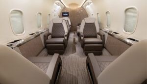 Private jet cabin in neutral palette, with diamond-pattern stitching on seats