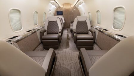 Private jet cabin in neutral palette, with diamond-pattern stitching on seats