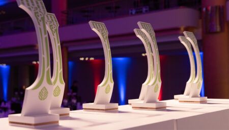 Curved white trophies shaped as sections of aircraft fuselage, with green decoration