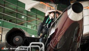 Maintenance technician working on jet engine in hangar