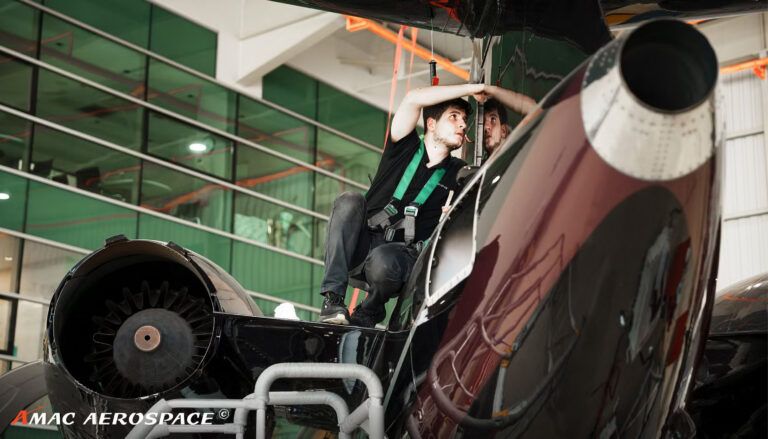 Maintenance technician working on jet engine in hangar