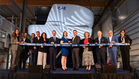 Ribbon-cutting ceremony with flight simulator backdrop